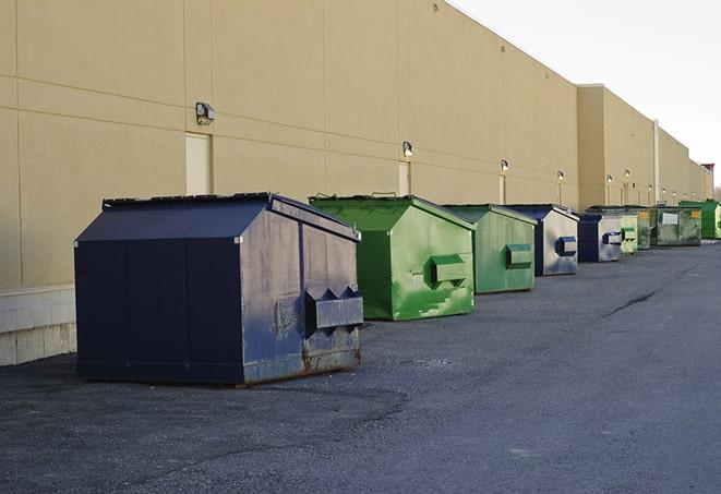 a row of yellow and blue dumpsters at a construction site in Berkeley Lake, GA